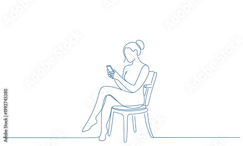 Fotografija Woman sitting on a chair engrossed in her smartphone activity