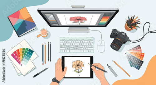 Overhead view of a graphic designer workspace including a computer monitor, digital tablet, camera, color palettes, and various drawing tools.