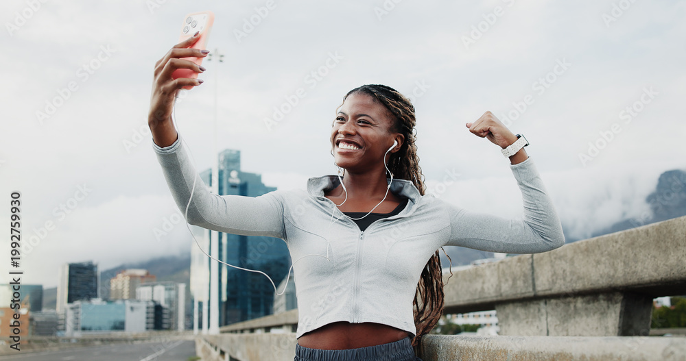 Fototapeta premium Exercise, selfie and black woman in city with win, cardio workout or smile with music. Fist pump, earphones or runner celebrate for wellness, sports and playlist outdoor with fitness photography