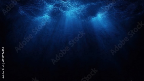 sunlit ocean surface with shafts of blue light piercing into dark deep water, evoking calm mystery and solitude