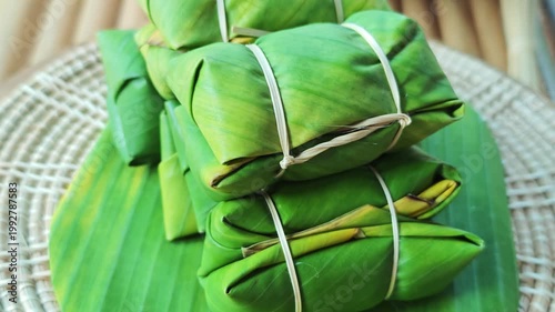 Khao Tom Mud or banana in sticky rice in fresh green banana leaf before cooking, popular dessert recipe in Thailand.