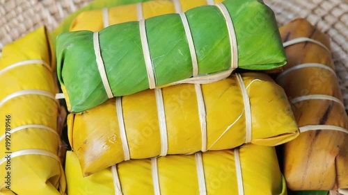 Khao Tom Mud or banana in sticky rice in fresh green banana leaf before cooking, popular dessert recipe in Thailand.