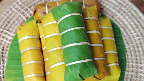 Khao Tom Mud or banana in sticky rice in fresh green banana leaf before cooking, popular dessert recipe in Thailand.
