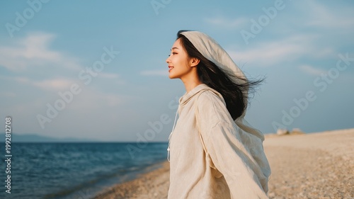 Young asian woman in linen outfit walking seaside, summer breeze