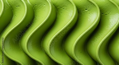 Close-up of vibrant green creamy texture with smooth, wavy, and repetitive patterns, resembling piped frosting or soft-serve ice cream.