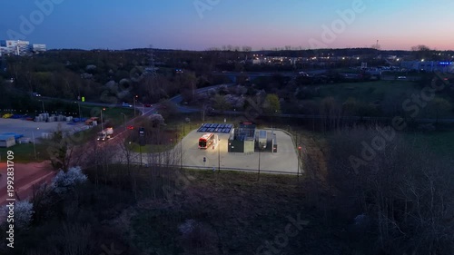 Modern hydrogen refueling station for public transport buses at twilight; Sustainable zero-emission city infrastructure; Hydrogen fuel cell technology for suburban transit; Clean energy terminal on th