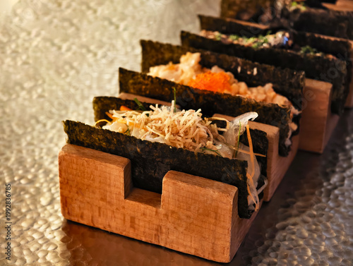 Close-up nori tacos neatly arranged on a wooden holder