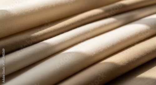 Soft Fabric Layers: Close-up of neatly arranged, soft fabric layers, bathed in warm sunlight, evoking a sense of luxury, comfort, and the tactile allure of textiles.