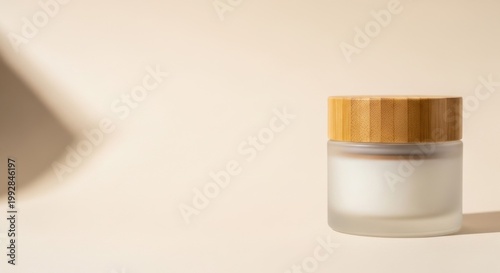 Cream Jar on Beige Background: A natural skincare jar with a wooden lid sits elegantly, with soft shadows against a warm background