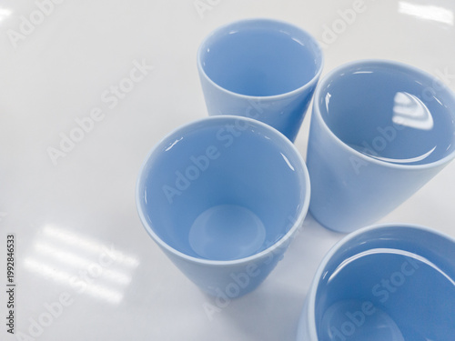 Minimal photo of blue ceramic cups filled with water on white surface. Perfect for kitchen, lifestyle, and design themes.