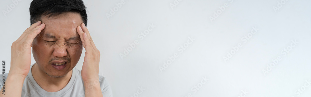 Fototapeta premium Asian man with severe headache pressing temples isolated on gray background