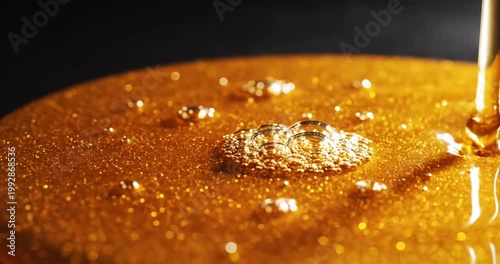 Golden syrup pouring onto a reflective surface, shimmering with bubbles and highlights