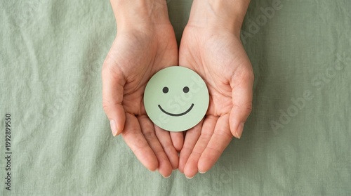 Hands holding a smiling symbol representing happiness and positivity in a soft natural lighting setting