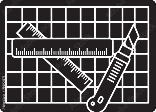 Utility knife and ruler on cutting mat.