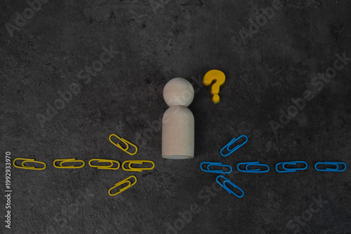 Decision Making Concept A Wooden Figure Facing a Crossroads with Paperclips