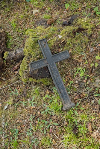 Old, weathered cast-iron grave cross in an old cemetery, Muhu, Estonia, Europe.