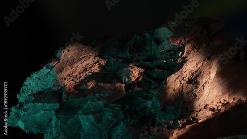 Wide shot rock formation with moving light and green tones