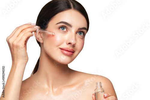 Young beautiful woman applying face serum with pipette. Cosmetic procedures for facial skin care