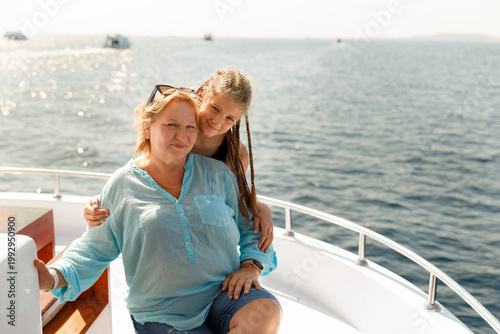Family portrait of mature woman and girl on boat trip