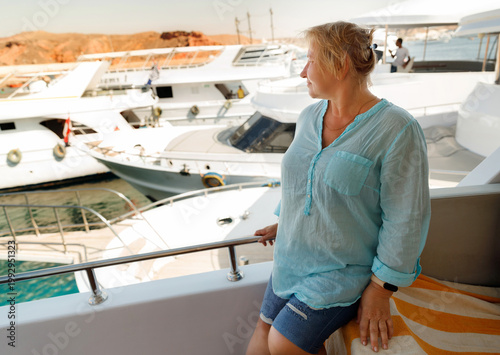 Senior woman in blue shirt looking at sea from boat deck