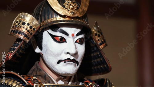 Close-up of a Japanese Noh theater actor in elaborate samurai armor and white face paint with red eyes, under dramatic stage lighting.