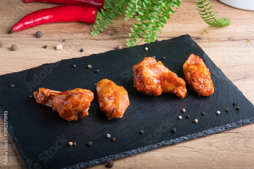 Fried chicken on black plate. Delicious hot meal with fast food.