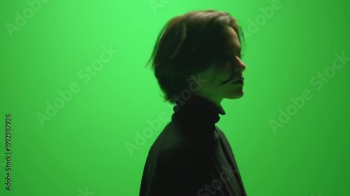 Female Silhouette Against Green Screen Looking Up and Down.