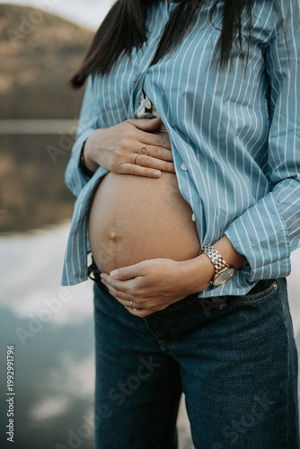 Femme enceinte tenant son ventre nu avec tendresse lors d'une séance photo de maternité 