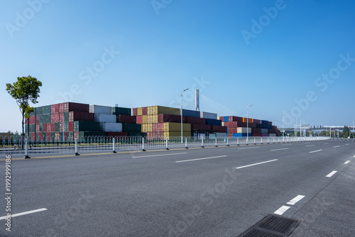 Shipping containers stacked and empty asphalt road background