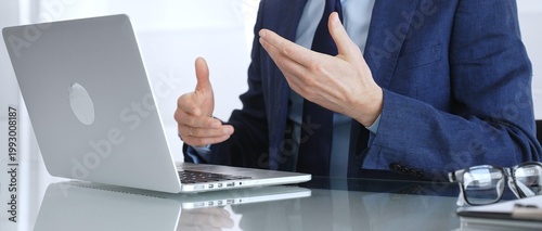 Obraz na plátne Businessman participating in a video conference, expressing ideas with hand gest