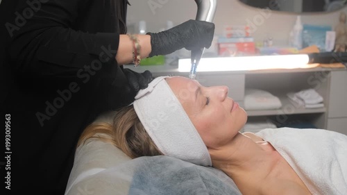 Female client receiving a professional facial water peeling treatment in a modern beauty salon