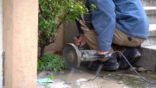 Construction worker cutting concrete with an angle grinder power tool