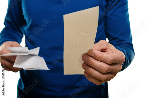 Valokuva Man holding receipts and envelope, tense expression while checking purchases and