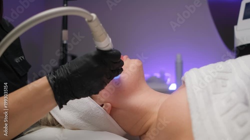 Professional beautician performing a rejuvenating hydrafacial procedure on a client's face. Modern cosmetology for skin cleansing and anti-aging care