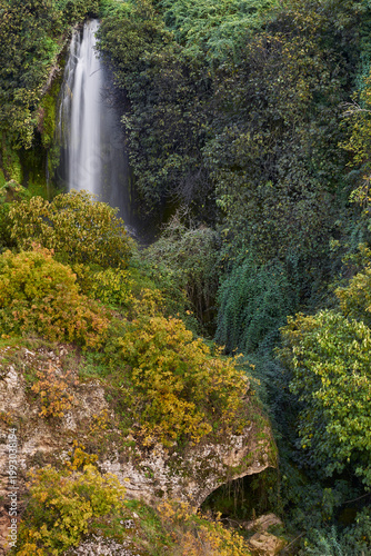 Waterfall surrounded by autumn forest, also known as Cola de Caballo (Horsetail Falls), in the Infiernos de Loja area, Granada province, Spain.