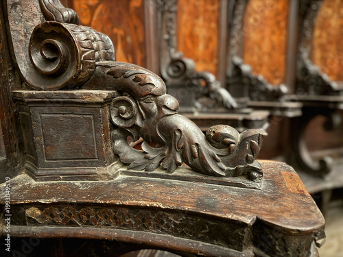 Photos CAPUA, ITALY - NOV 2025: Close-up of a wood-carved armrest in the choir stalls at the Church of Saint Mary of the Announcement, featuring a putto riding a mythical creature