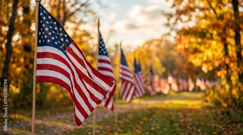 Many American flags line a beautiful autumn path bathed in warm sunlight with colorful fall leaves