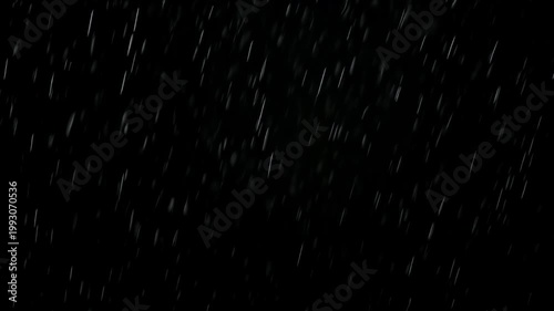Abstract rain drops falling against a black background create a dramatic weather effect for overlays