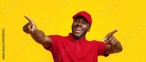 The smiling delivery man in red uniform pointing with cheerful expression on yellow background