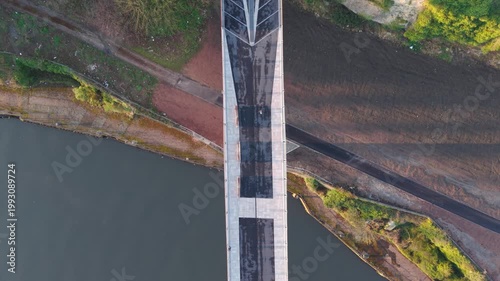 Aerial drone shot flying backward and tilting up from a top-down view of the Keel Crossing to reveal Keel Square and the modern city skyline of Sunderland at sunrise.
