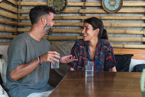 Smiling man and woman having a relaxed conversation at a cafe table