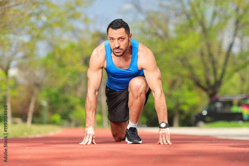 Obraz premium Muscular man in start position for running