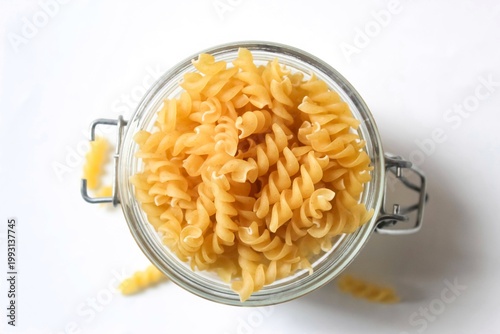 top view of fusilli pasta in a glass jar isolated on a white background