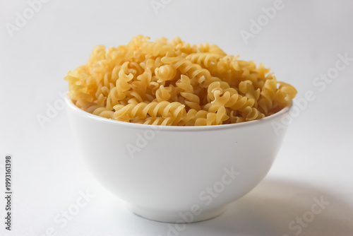 fusilli pasta in a bowl on a white background
