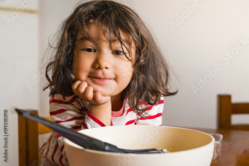 littl toddler girl baking at home in the kitchen with flour, concept activity with children, cooking together with complicity