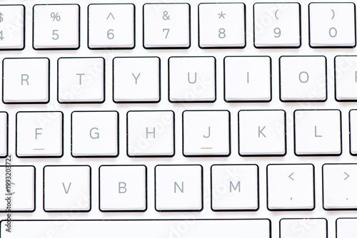 Close up white computer keyboard on blue background. View from above.