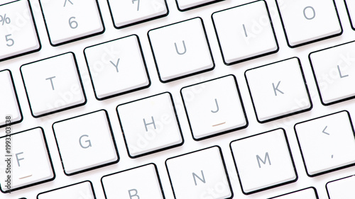 Close up white computer keyboard on blue background. View from above.