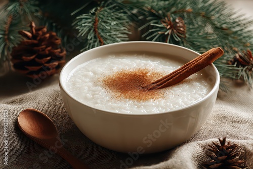 A Comforting Bowl Of White Rice Porridge Topped With Cinnamon And Sprinkles Presented On A Rustic Wooden Surface Beside A Spoon And Decorated With Pine Cones And Green Pine Needles For A Cozy Winter