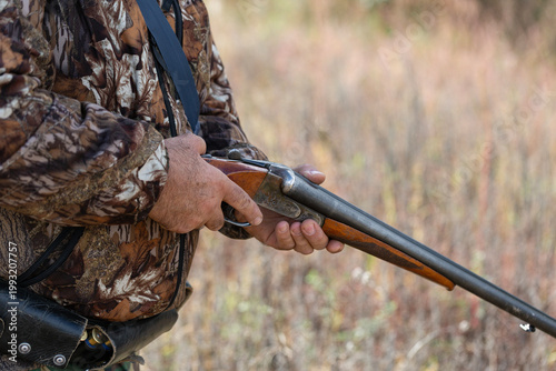 Close-up of a hunter's hand with a gun. Medium shot of a hunter with a weapon.
