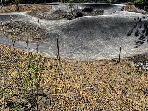 construction of a dirt bike track with burlap netting and wooden stakes in a rural setting